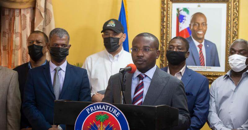 Il presidente ad interim di Haiti Claude Joseph durante una conferenza stampa presso la sua residenza a Port-au-Prince, giovedì 8 luglio. Sullo sfondo, una foto del presidente assassinato, Jovenel Moïse (AP Photo/ Joseph Odelyn)