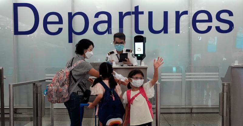 Una famiglia in partenza dall'aeroporto di Hong Kong, lo scorso 30 giugno (AP Photo/ Vincent Yu)