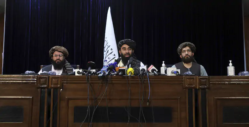 Il portavoce dei talebani, Zabihullah Mujahid (al centro), durante una conferenza stampa a Kabul (AP Photo/Rahmat Gul)