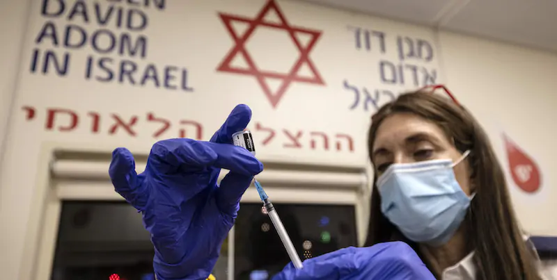 Una medica israeliana si prepara a somministrare una terza dose di vaccino in un ospedale di Tel Aviv. (AP Photo/Tsafrir Abayov)