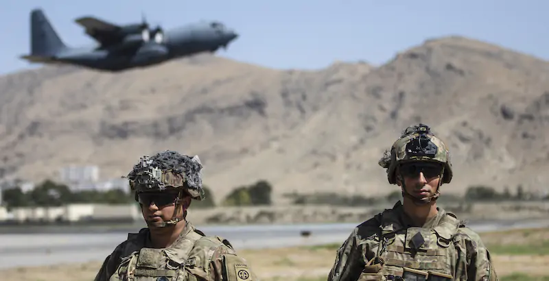 Due soldati americani a Kabul, con sullo sfondo un aereo impegnato nelle operazioni di evacuazione (Department of Defense via AP)