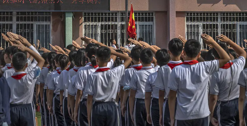 Alunni di una scuola elementare di Pechino durante la cerimonia dell'alzabandiera (Kevin Frayer/Getty Images)
