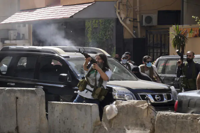 Una manifestante spara contro i palazzi in cui si trovavano i "cecchini" (AP Photo/Hassan Ammar)