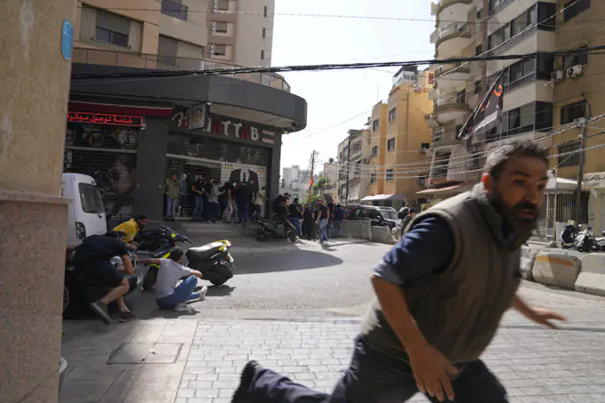 Un uomo fugge durante la sparatoria (AP Photo/Hassan Ammar)