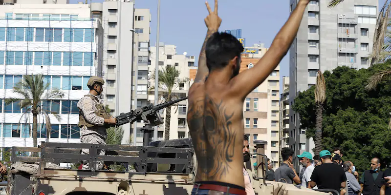 Un manifestante di Hezbollah e sullo sfondo un soldato a bordo di un mezzo dell'esercito libanese, durante gli scontri di giovedì (AP Photo/Bilal Hussein)