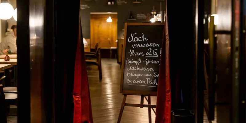 Il cartello di un ristorante di Innsbruck in cui si spiega che l'accesso è consentito soltanto alle persone vaccinate o guarite dopo aver contratto il coronavirus (Photo by Jan Hetfleisch/Getty Images)
