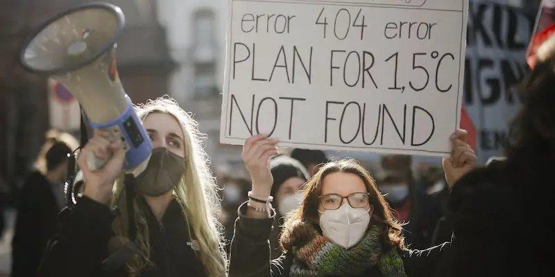 Durante una manifestazione per il clima a Zurigo, in Svizzera, il 6 novembre 2021; il cartello critica la COP26 in corso a Glasgow e dice: «Errore 404, il piano per 1,5 °C non è stato trovato» (Michael Buholzer/Keystone via AP, La Presse)