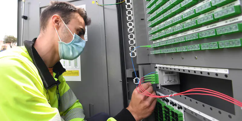 Un tecnico controlla il cablaggio dei cavi della fibra ottica di una centralina a Peschiera Borromeo, Milano, il 14 maggio 2021 (ANSA/DANIEL DAL ZENNARO)