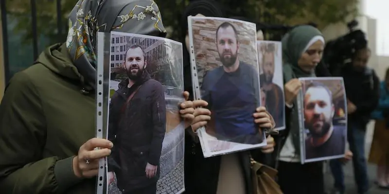 Alcune persone con in mano foto di Zelimkhan Khangoshvili durante una protesta davanti all'ambasciata tedesca a Tbilisi, in Georgia, nel 2019. (ANSA/EPA/ZURAB KURTSIKIDZE)