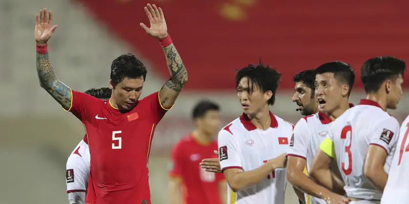 Il calciatore cinese Zhang Linpeng insieme ad altri giocatori, della squadra avversaria (AP Photo/Kamran Jebreili)