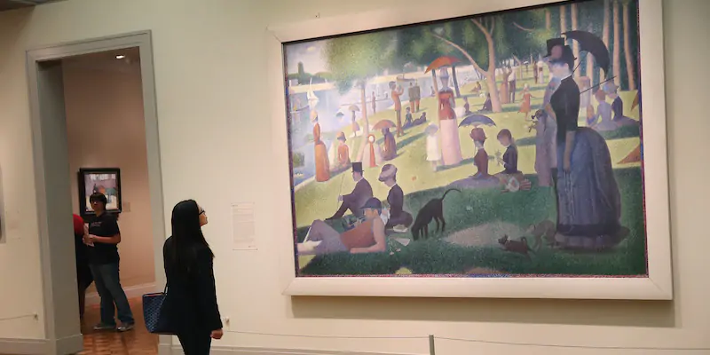 Una visitatrice dell'Art Institute di Chicago osserva "Una domenica pomeriggio sull'isola della Grande-Jatte" di Georges Seurat, il 17 settembre 2014 (Scott Olson/Getty Images)