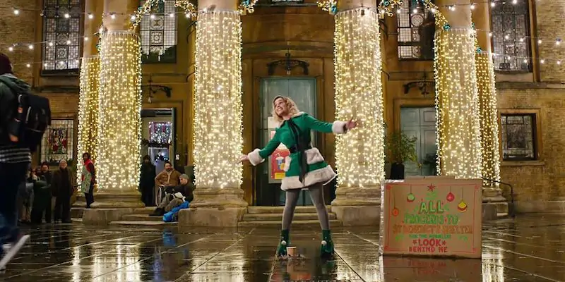 Emilia Clarke in una scena di "Last Christmas" (2019) in cui la protagonista canta per raccogliere fondi per un rifugio per persone senza casa
