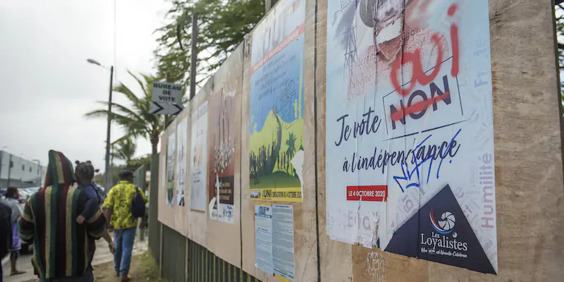 Manifesti vicino a un seggio elettorale della Nuova Caledonia, durante il secondo referendum per l'indipendenza, a ottobre del 2020 (AP Photo/Mathurin Derel)