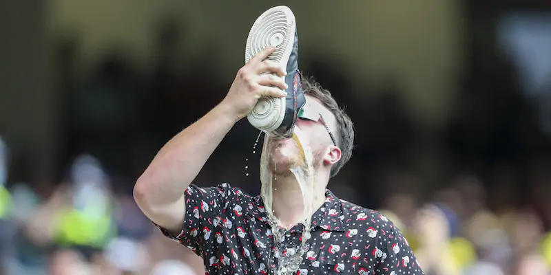 Uno spettatore australiano beve dalla propria scarpa durante un famoso torneo di cricket tra Australia e Inghilterra. Melbourne, 27 dicembre 2021 (AP Photo/ Asanka Brendon Ratnayake)