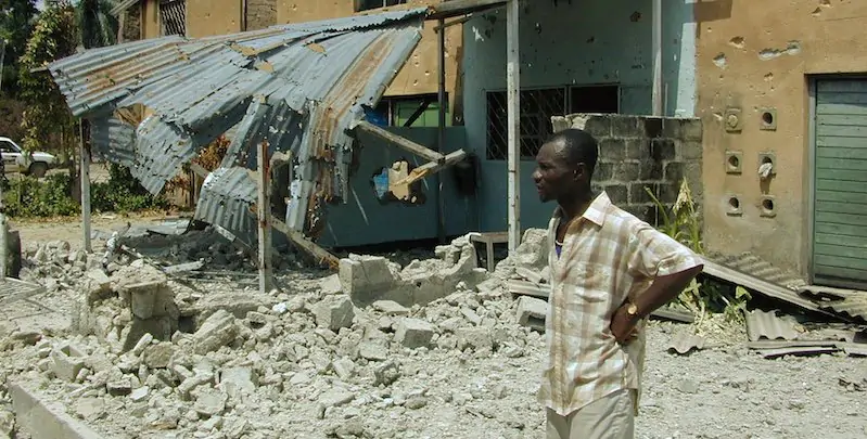 Un cittadino congolese guarda un edificio danneggiato durante il conflitto nella Repubblica democratica del Congo alla fine degli anni Novanta, Kisangani (AP Photo/Hrvoje Hranjski, File)