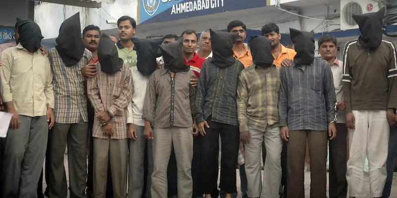 Alcune delle persone arrestate ad Ahmedabad nel 2008, incappucciate per proteggere la propria identità (AP Photo/Ajit Solanki, File)
