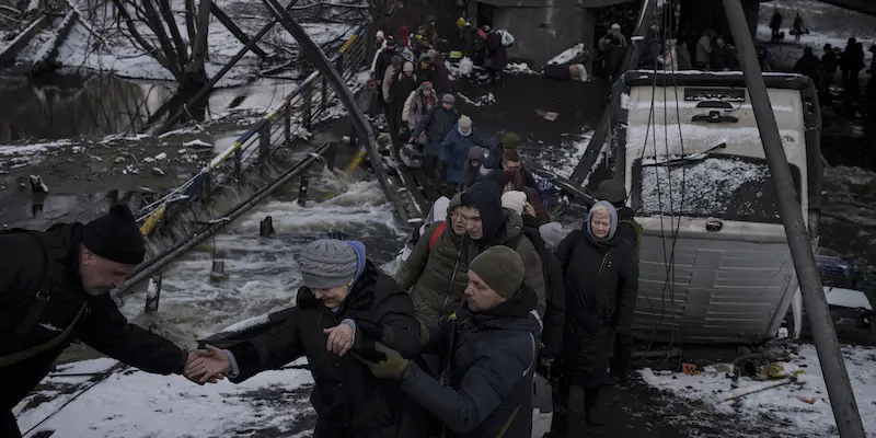 Persone ucraine che provano a lasciare Irpin, a nord-ovest di Kiev (AP Photo/ Felipe Dana)