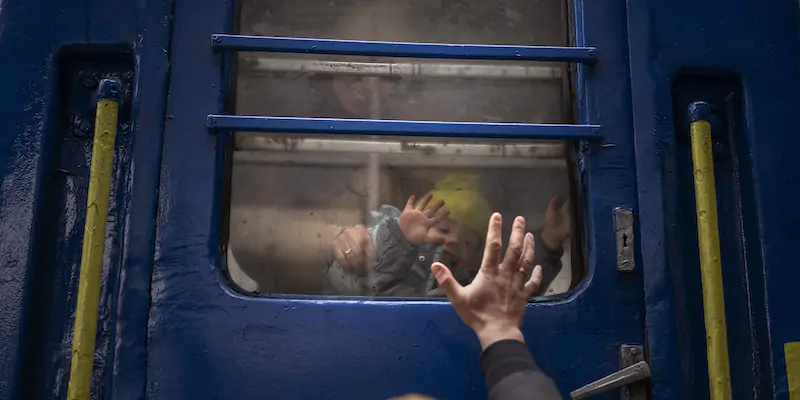 Un uomo saluta la moglie e il figlio in partenza per Leopoli dalla stazione centrale di Kiev, in Ucraina (AP Photo/Emilio Morenatti)