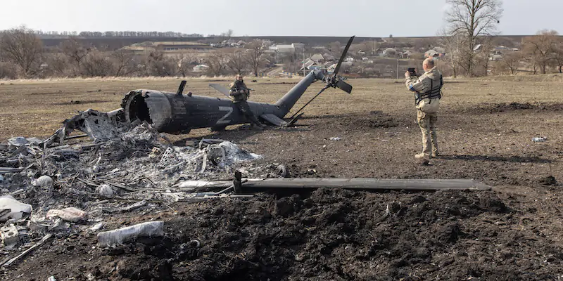 Un soldato ucraino in posa con i resti di un elicottero russo a Malaya Rohan, 20 chilometri a sud est di Kharkiv, il 31 marzo 2022 (Chris McGrath/Getty Images)