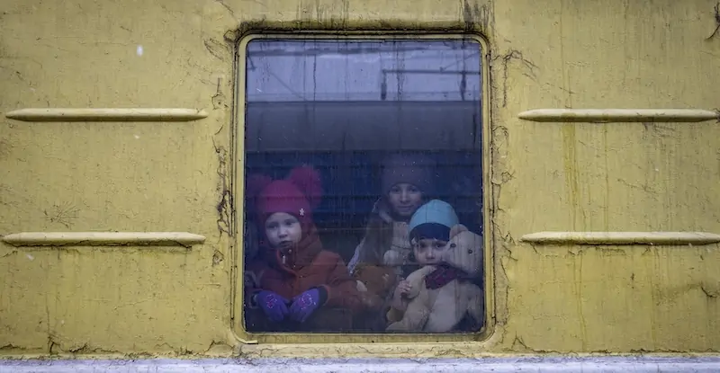 Tre bambini guardano fuori dalla carrozza di un treno usato per l'evacuazione dei civili da Kharkov e diretto a Leopoli, durante una fermata alla stazione di Kiev, 3 marzo
(AP Photo/Andriy Dubchak)