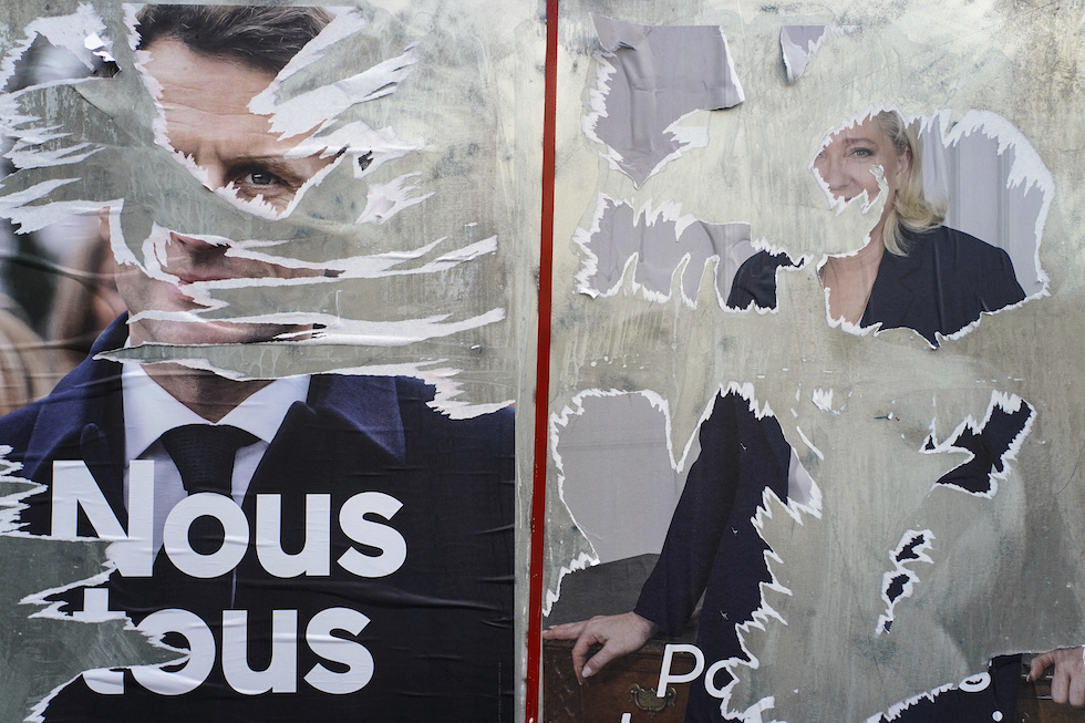Manifesti strappati dei candidati al ballottaggio delle elezioni presidenziali francesi, Emmanuel Macron e Marine Le Pen (AP Photo/Laurent Cipriani)