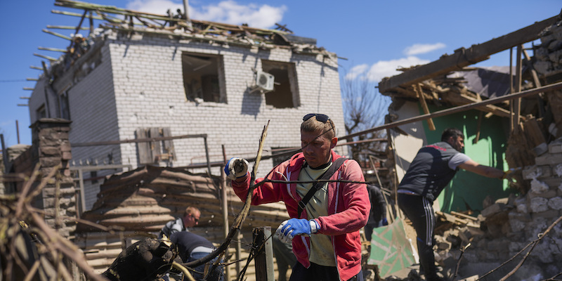 Alcune persone tra i detriti di un edificio bombardato a Zaporizhzhia, in Ucraina, lo scorso 28 aprile (AP Photo/ Francisco Seco)