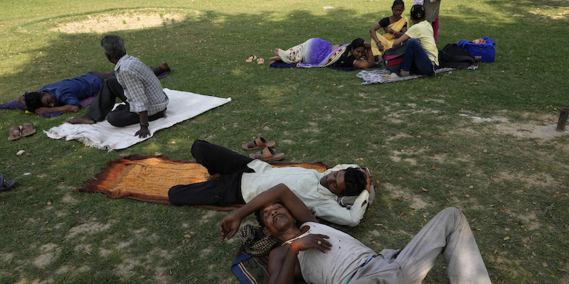 Un gruppo di persone di Lucknow, in India, che ha cercato sollievo alle alte temperature del 28 aprile 2022 in una zona ombrosa di un parco (AP Photo/Rajesh Kumar Singh)