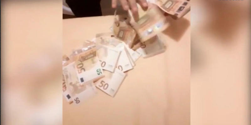 Il fermo immagine di uno dei video di TikTok in cui gli indagati mostravano i soldi ottenuti grazie alla truffa (ANSA)