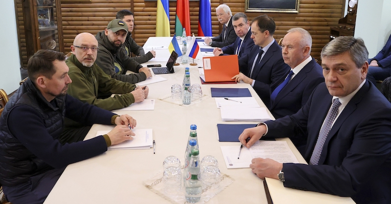 Le delegazioni ucraina (a sinistra) e russa (a destra) durante le prime fasi del negoziato il 7 marzo in Bielorussia (Maxim Guchek/BelTA Pool Photo via AP)