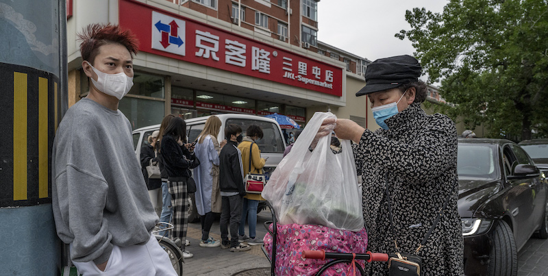 Alcune persone in fila davanti a un supermercato di Pechino (Kevin Frayer/Getty Images)