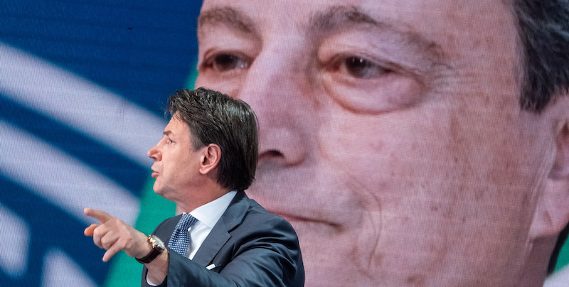 Il leader del Movimento 5 Stelle, Giuseppe Conte, e dietro una foto del presidente del Consiglio, Mario Draghi. (Mauro Scrobogna /LaPresse)
