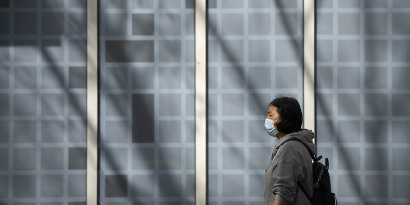 Una donna con una mascherina a Pechino, in Cina (AP Photo/Mark Schiefelbein)