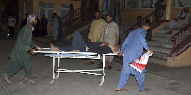 Un uomo ferito viene portato via dopo uno degli attentati compiuti dall'ISIS nel nord dell'Afghanistan (AP Photo/Masih Paeiz)