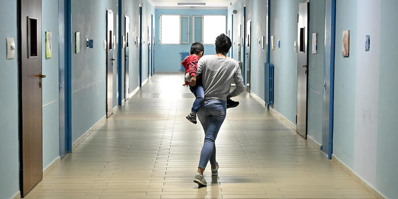 Una donna detenuta con in braccio suo figlio in un corridoio nella Casa circondariale - Istituto a Custodia Attenuata per Madri (ICAM) di Lauro, Avellino, il 7 aprile 2022 (ANSA/ALESSANDRO DI MEO)