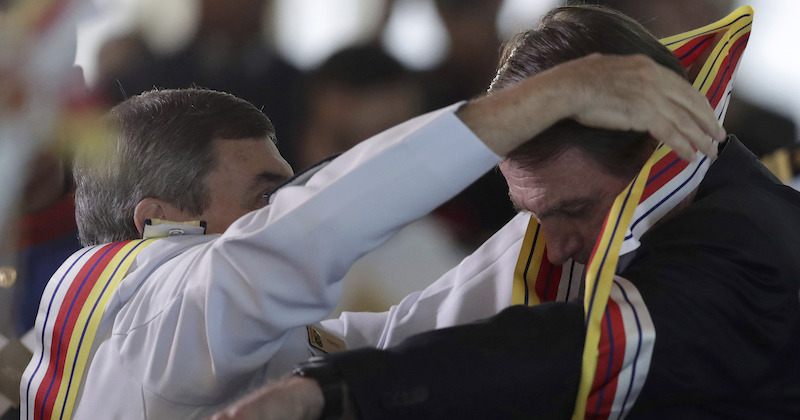 Il presidente brasiliano Jair Bolsonaro riceve una medaglia al valore militare nel marzo del 2019 (AP Photo/ Eraldo Peres, File)