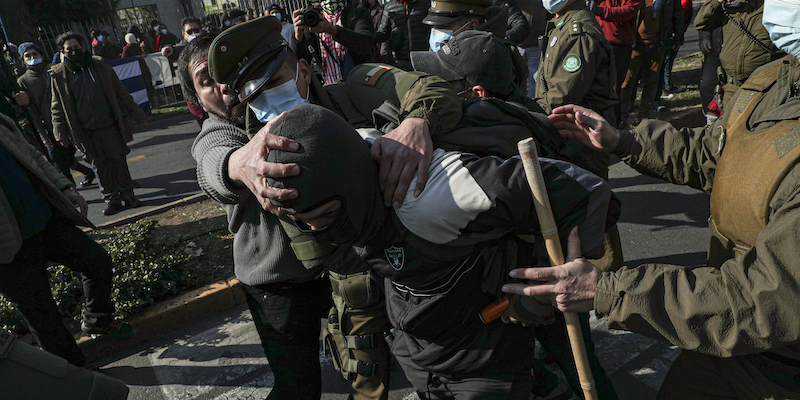 Uno scontro tra un sostenitore del governo cubano e un manifestante coinvolto nelle proteste antigovernative di fronte all'ambasciata cubana a Santiago, in Cile, a luglio del 2021 (AP Photo/Esteban Felix)