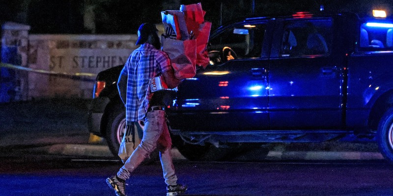 Un uomo passa davanti a un'auto della polizia sul luogo della sparatoria, in Alabama (AP Photo/Butch Dill)