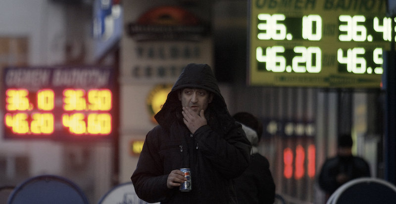 Un uomo cammina davanti a dei cambiavalute a Mosca (AP Photo/Ivan Sekretarev)