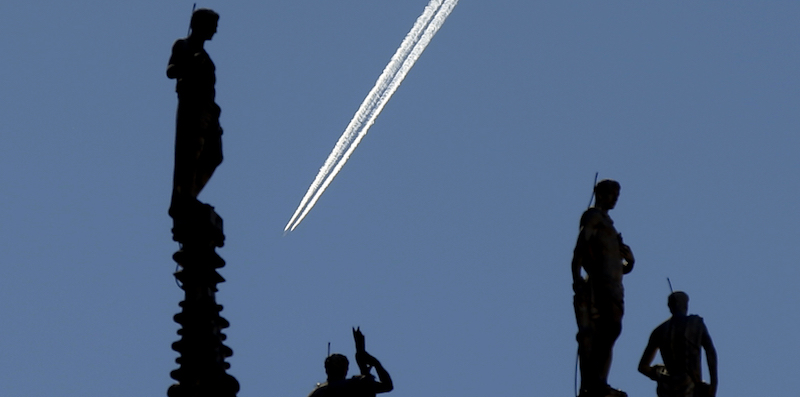 Un aereo sorvola le guglie del Duomo di Milano. (AP Photo/Luca Bruno)