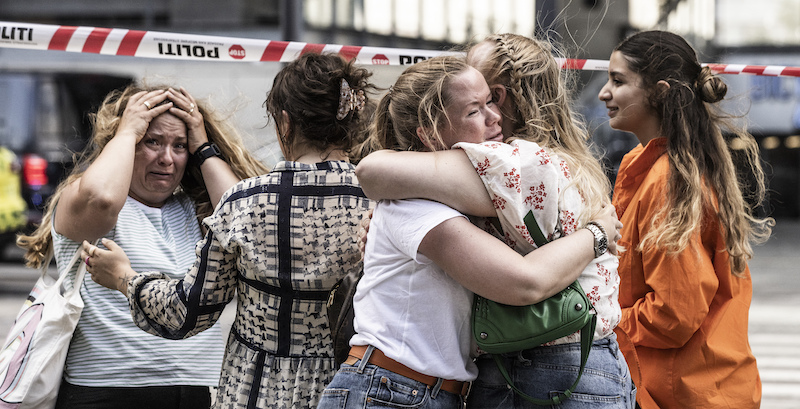 Alcune persone fuori dal centro commerciale dove è avvenuto l'attacco (Olafur Steinar Rye Gestsson/Ritzau Scanpix via AP)