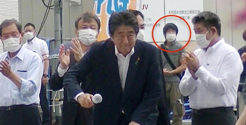Tetsuya Yamagami alle spalle di Shinzo Abe prima che gli sparasse (ANSA/EPA/JIJI PRESS)