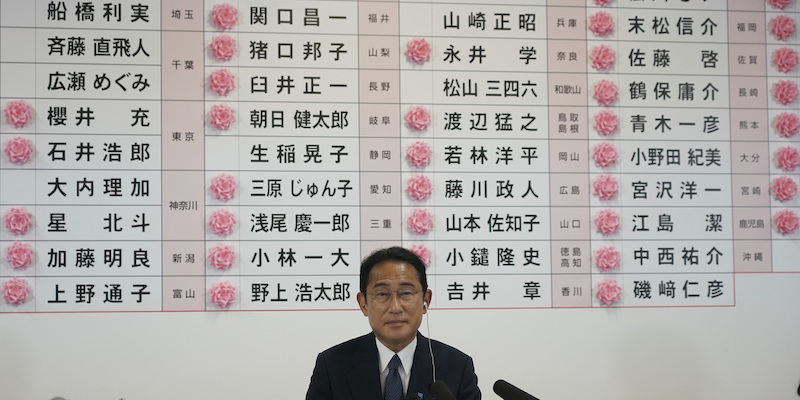 Il primo ministro giapponese Fumio Kishida davanti a un tabellone con i nomi dei candidati del Partito Liberal Democratico che hanno ottenuto un seggio alla camera alta del Parlamento, indicati da fiocchi rosa. Tokyo, 10 luglio (Toru Hanai, Pool Photo via AP)
