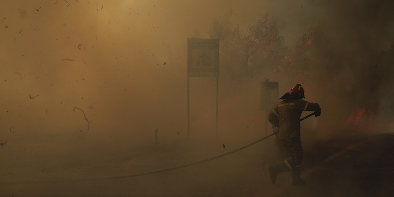 Un pompiere cerca di spegnere un incendio nella città di Megara, a ovest di Atene, 20 luglio 2022 (AP Photo/Petros Giannakouris, File)