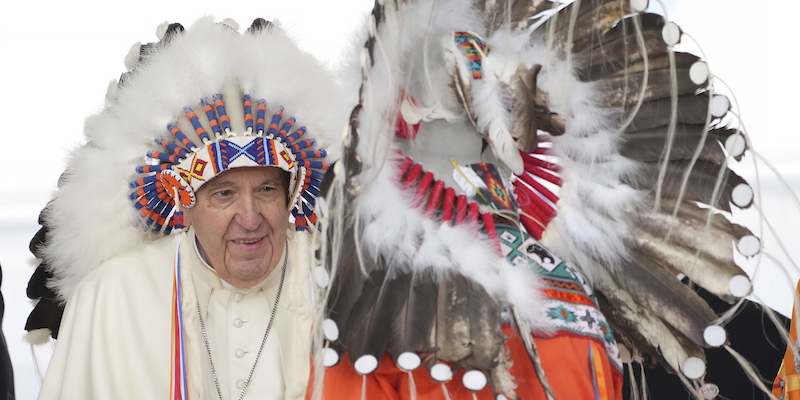 Papa Francesco indossa un copricapo tradizionale di un popolo indigeno durante una visita a Maskwacis, in Alberta, durante il suo viaggio in Canada, lunedì 25 luglio (Nathan Denette/ The Canadian Press via AP)