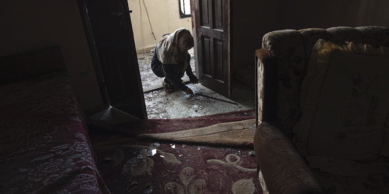 Una donna cerca di ripulire la sua casa danneggiata dai bombardamenti a Rafah, nella Striscia di Gaza, 7 agosto 2022 (AP Photo/Fatima Shbair)