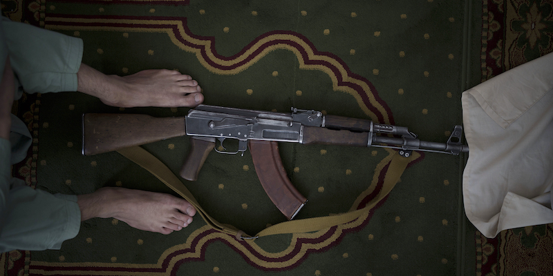 Un combattente talebano con un fucile d'assalto, durante una preghiera del venerdì a Kabul, in Afghanistan (AP Photo/Felipe Dana)