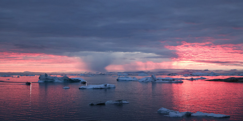 Tramonto e pioggia nella baia di Disko, in Groenlandia, a nord del Circolo polare artico, il 4 settembre 2021 (Mario Tama/Getty Images)