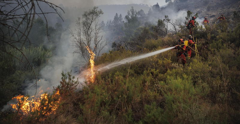 Vigili del fuoco spengono un incendio nella provincia di Castellón. (ANSA/EPA/BIEL ALINO)