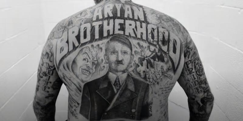 I tatuaggi di un membro della gang di suprematisti bianchi Universal Aryan Brotherhood (YouTube)