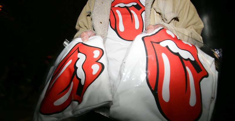 Un uomo vende magliette con il logo dei Rolling Stones prima di un concerto a Shanghai (Cancan Chu/Getty Images)
